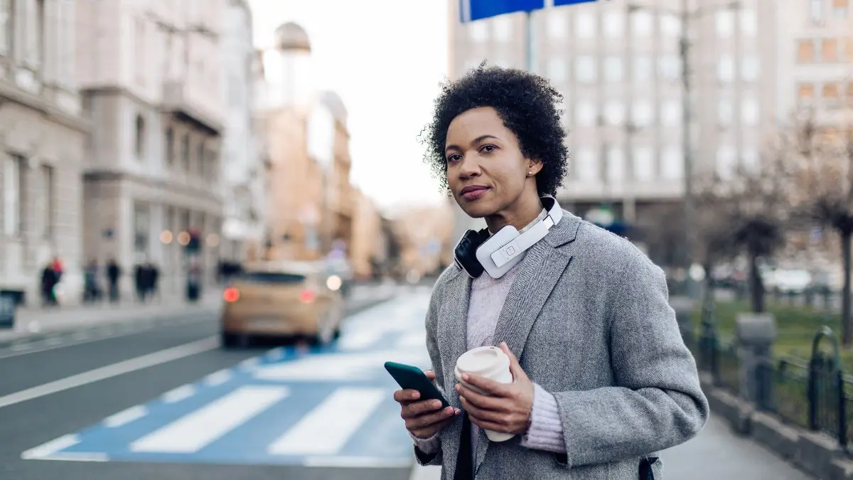 Woman with headphones on a city street